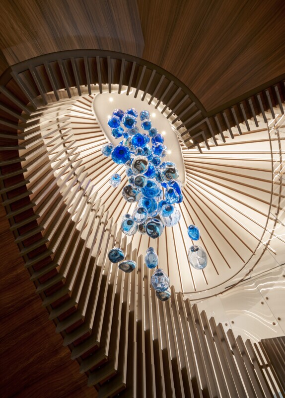 Haynes Boone office showcasing a Tignum traditional starburst wood ceiling with a blue glass chandelier.