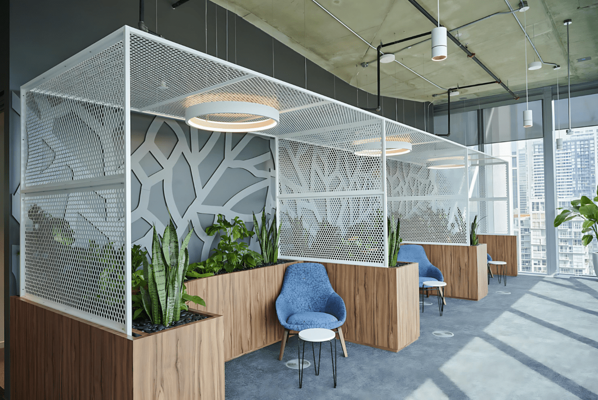 Intuit office showcasing Agilis custom perforated metal canopy partitions and wood-finished planters.