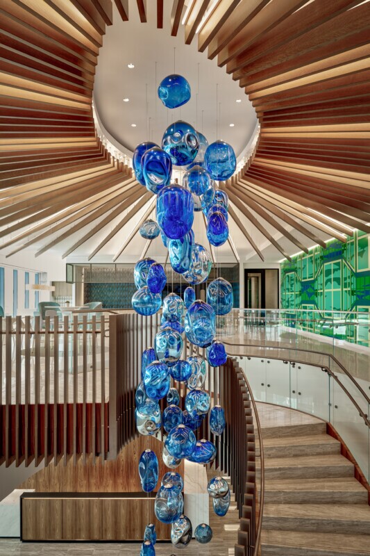 Haynes Boone office showcasing a Tignum traditional starburst wood ceiling with a blue glass chandelier.