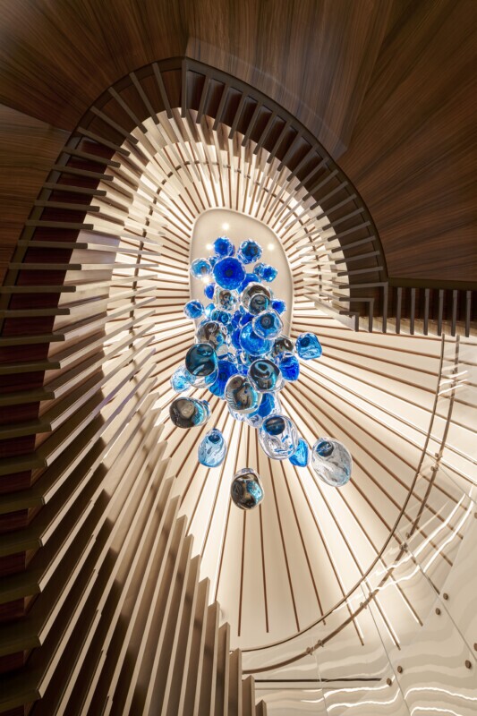 Haynes Boone office showcasing a Tignum traditional starburst wood ceiling with a blue glass chandelier.
