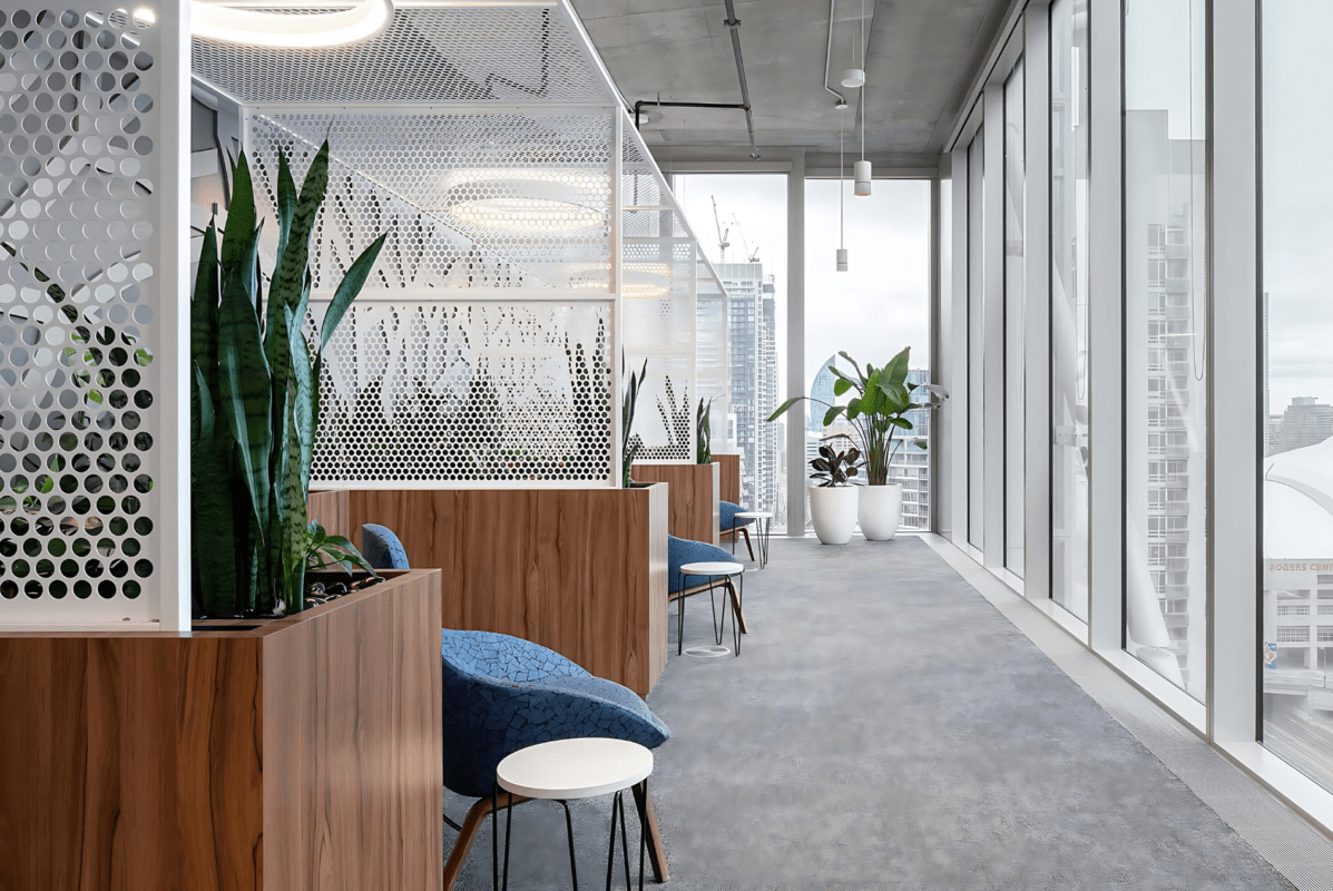 Intuit office showcasing Agilis custom perforated metal canopy partitions and wood-finished planters.
