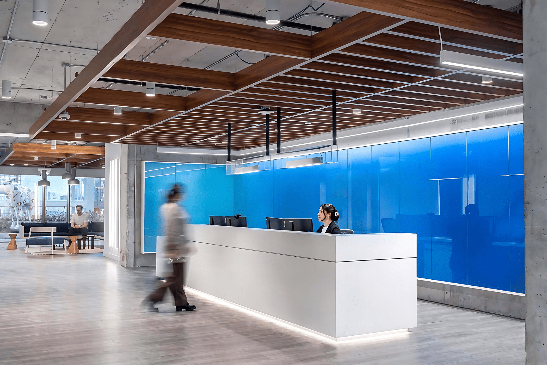 Intuit reception area showcasing a woodgrain baffle ceiling and a blue glass wall.