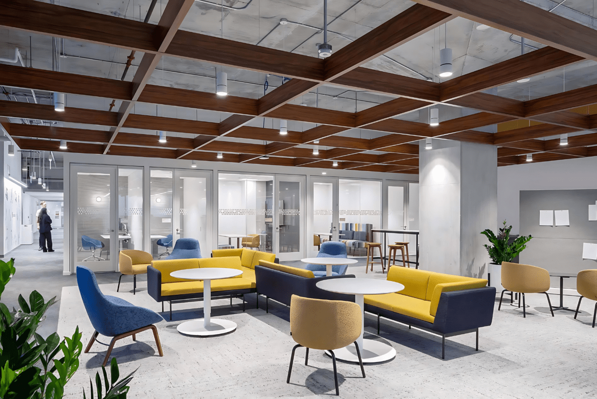 Intuit office lounge displaying a Tignum traditional starburst wood ceiling with vibrant yellow and blue seating.