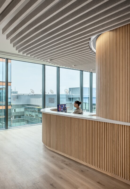 theScore Toronto reception featuring Silentia profile acoustic baffles and a curved wood-slat wall.