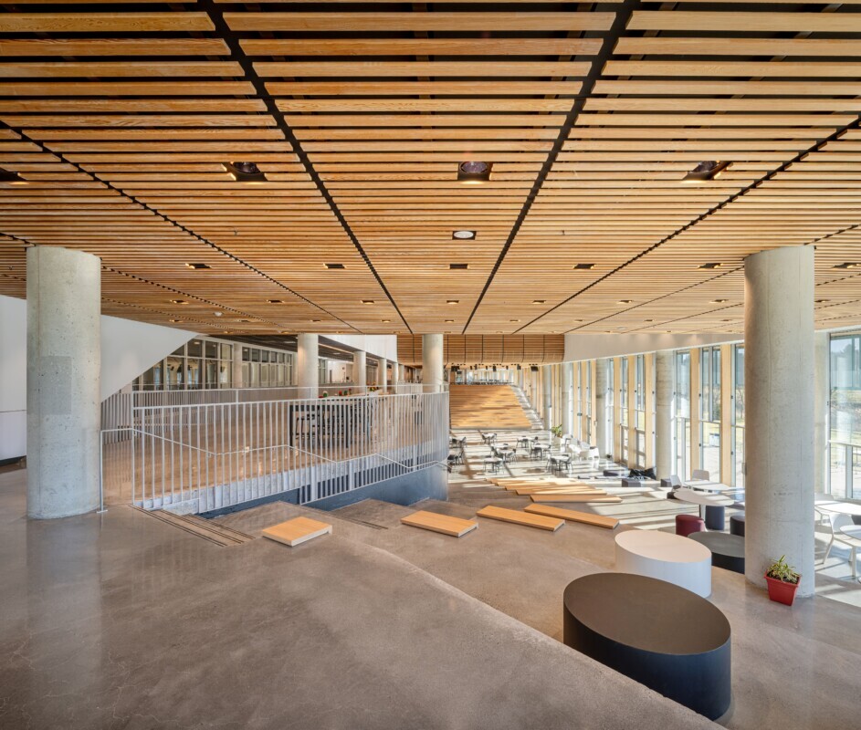 Custom wood LINE:Form Linear Planks system by Maxxit used on the ceiling of a large public room in located in Mirabel High School