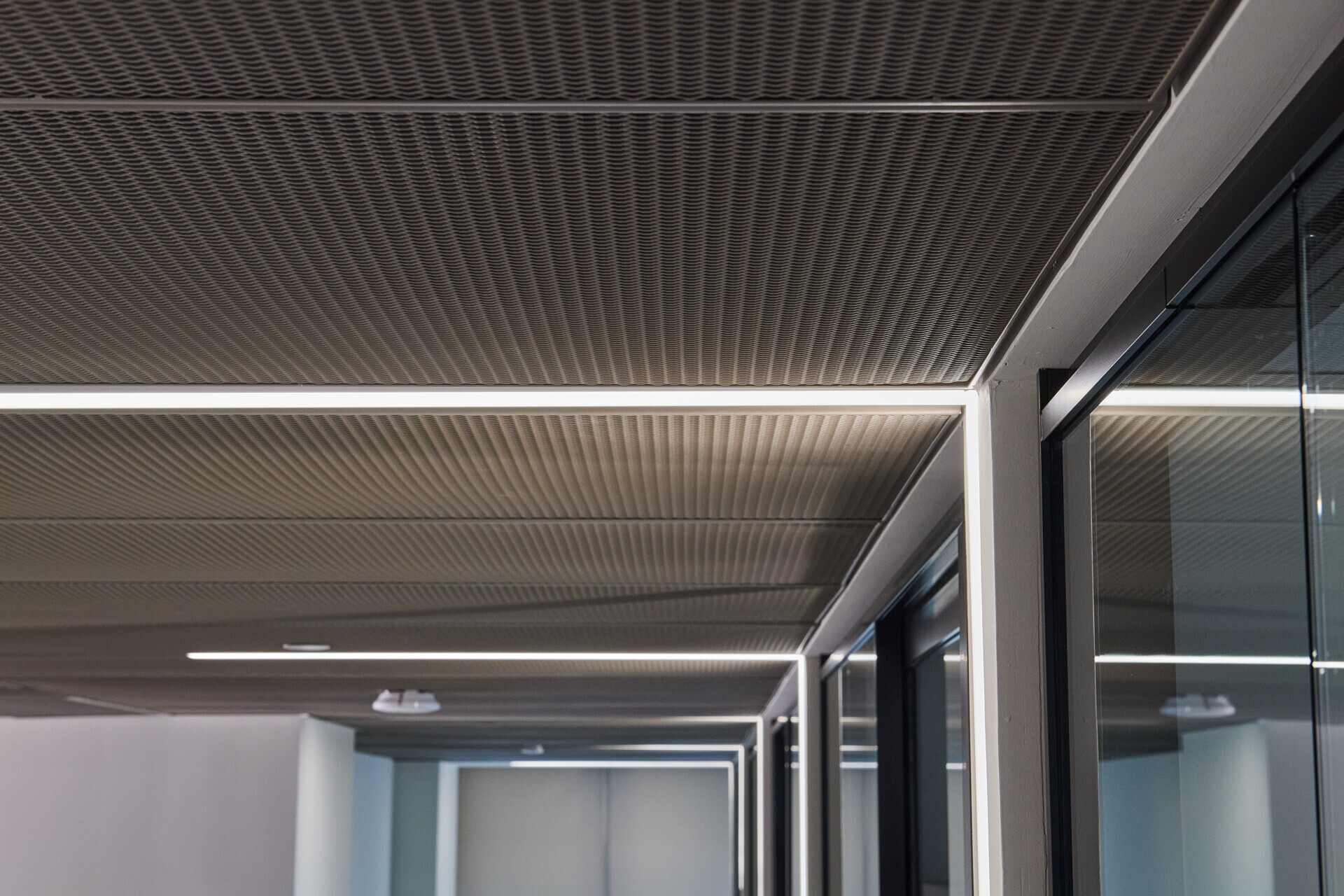 Interior ceiling of Pachulski Stang Ziehl & Jones LLP in New York, USA. Featuring the expanded PANEL:Form Mesh Ceiling Panels. Finished in a custom powdercoat champagne tone, these panels bring a touch of industrial elegance while integrating seamlessly with the space’s high-performance infrastructure.