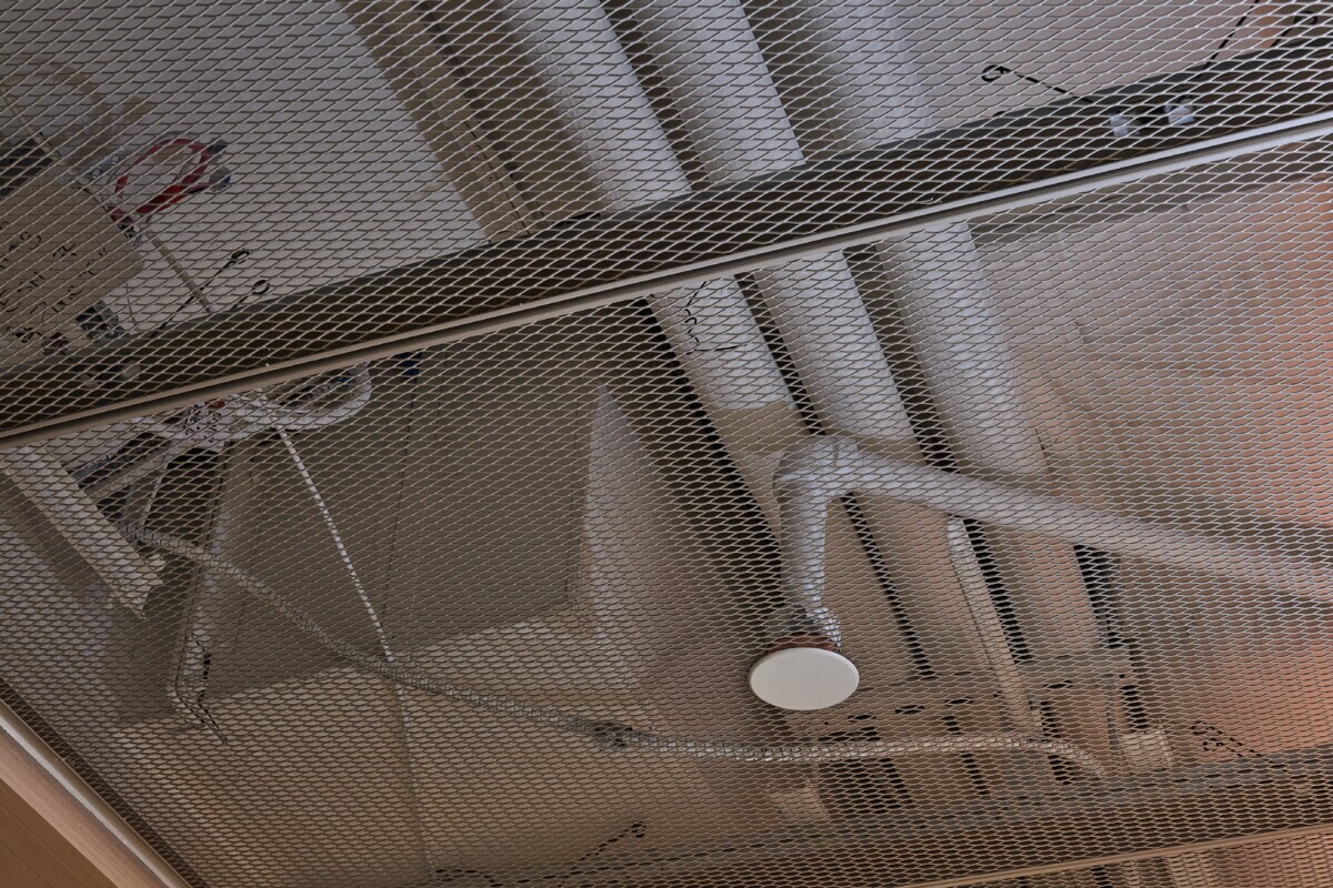 Interior ceiling of Pachulski Stang Ziehl & Jones LLP in New York, USA. Featuring the expanded PANEL:Form Mesh Ceiling Panels. Finished in a custom powdercoat champagne tone, these panels bring a touch of industrial elegance while integrating seamlessly with the space’s high-performance infrastructure.