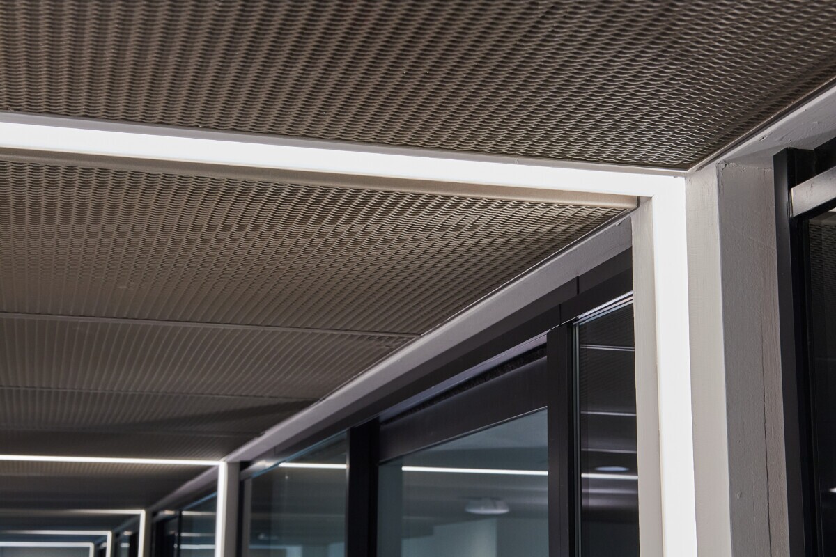 Interior ceiling of Pachulski Stang Ziehl & Jones LLP in New York, USA. Featuring the expanded PANEL:Form Mesh Ceiling Panels. Finished in a custom powdercoat champagne tone, these panels bring a touch of industrial elegance while integrating seamlessly with the space’s high-performance infrastructure.