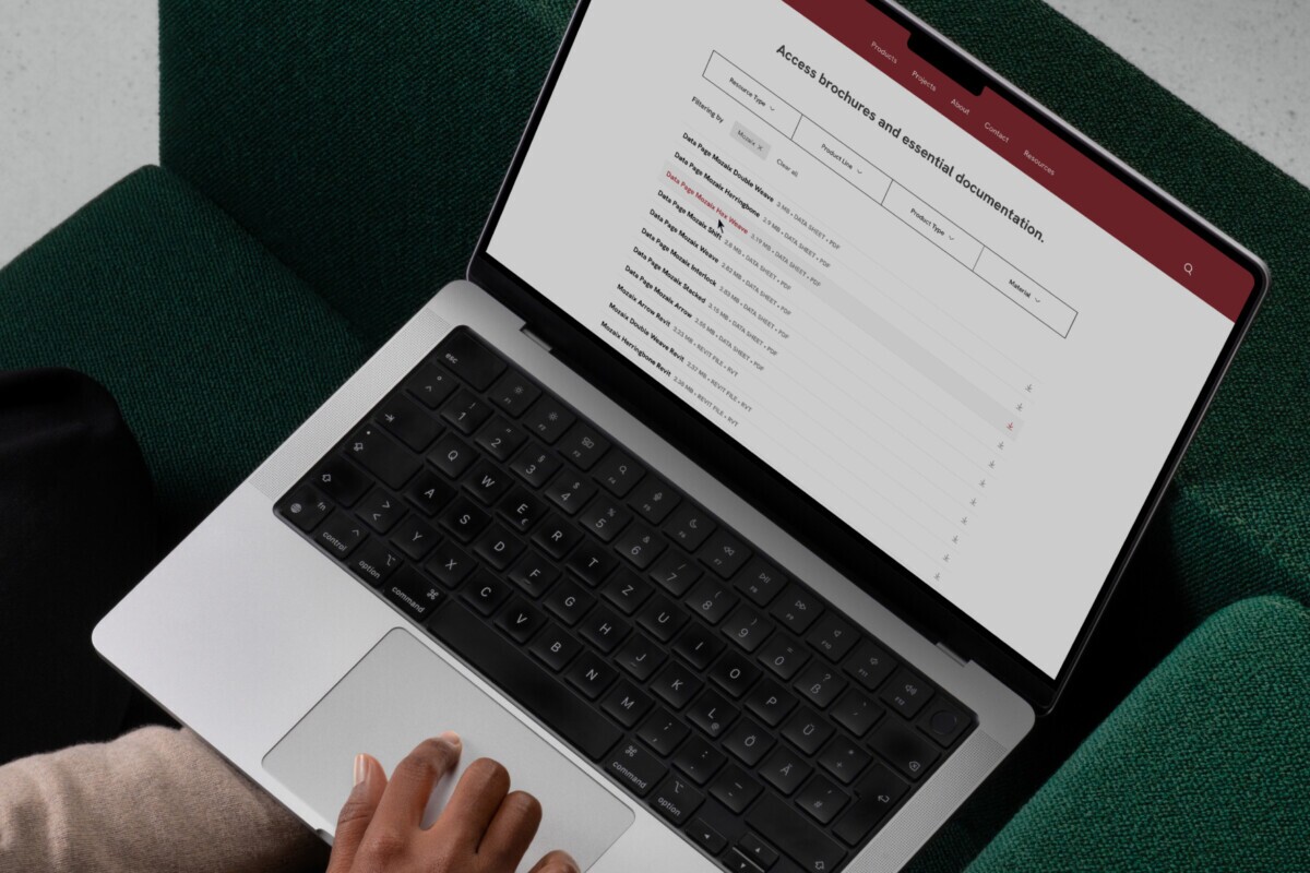 Maxxit website resource page showing brochures and essential documentation on a laptop.