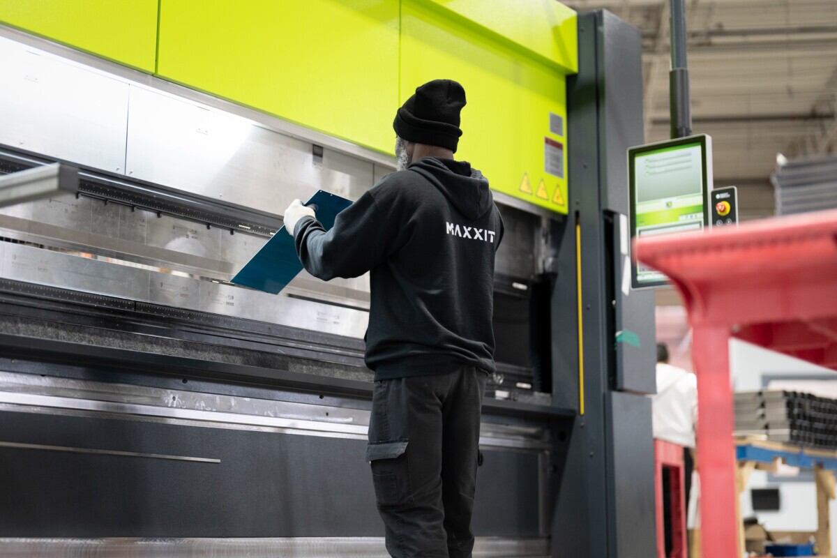 production staff bending a metal panel on machine