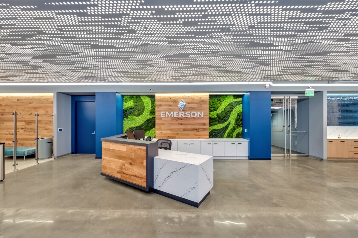 Emerson Electric office reception featuring Agilis backlit perforated wall and ceiling panels with wood accents.