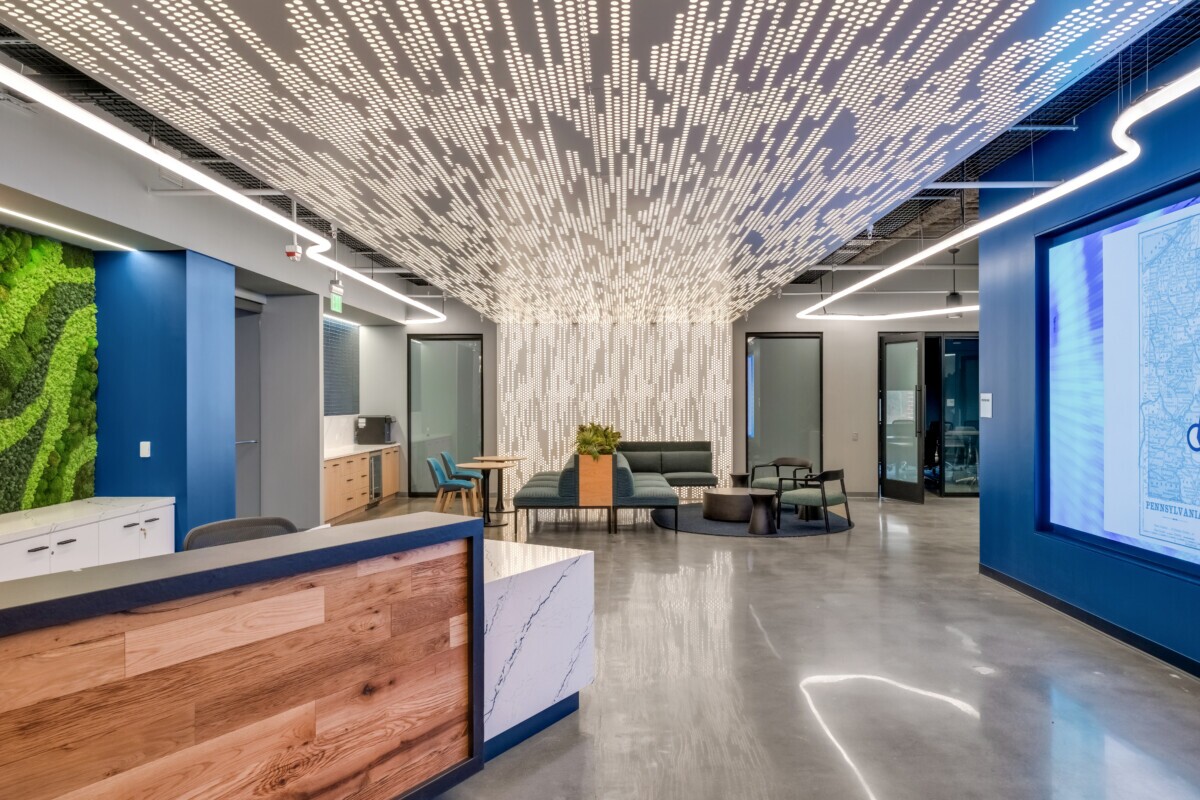Emerson Electric office reception featuring Agilis backlit perforated wall and ceiling panels with wood accents.