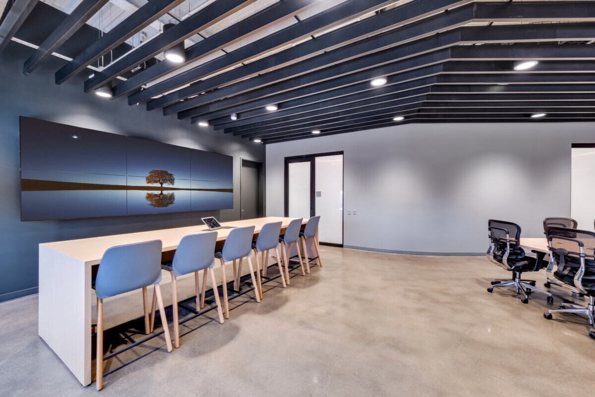 PM Emerson Electric workspace featuring Agilis traditional perforated baffle ceiling and long collaborative table.